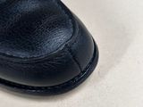 black leather slippers with buckles on a white surface