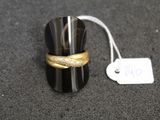 une bague noire surmontée d'une bande dorée