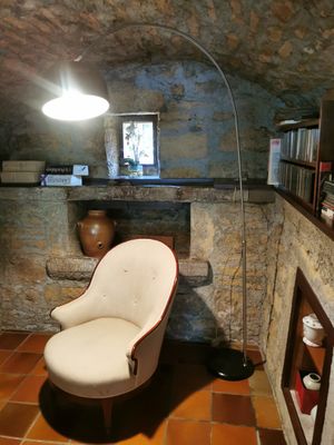 une chaise et une lampe dans une pièce aux murs en pierre