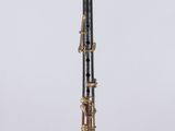 a black and gold clarinet on a clear surface