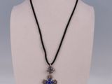a close up of a necklace with a cross on a mannequin