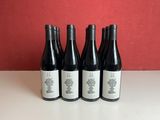 four bottles of wine are lined up on a table