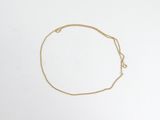 un bracelet à chaîne en or avec une breloque en forme de cœur sur fond blanc