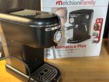 une photo d'une cafetière noire posée sur une table en bois