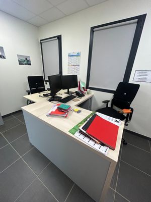 une image représentant un bureau avec un bureau et deux écrans