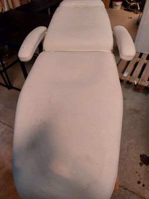une photo d'une table de massage blanche dans une pièce