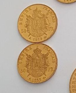 four gold coins are arranged in a row on a white surface
