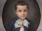 portrait of a young boy in a blue jacket and white bow tie