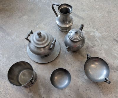quatre théières en argent et deux théières en argent posées par terre