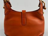 an image of a brown leather purse with a gold handle
