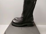 les bottes noires sont posées sur la boîte, sur la table