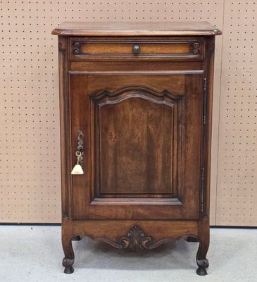 une image représentant une armoire en bois surmontée d'une cloche