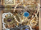 a wooden box filled with assorted jewelry and a clock