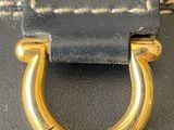 a black bag with a gold handle and a name engraved on it