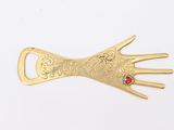 a close up of a gold hand with a red stone on it