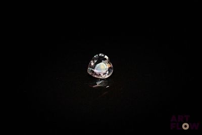 gros plan d'un diamant blanc sur une surface noire