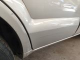 a close up of a white truck with a flat tire