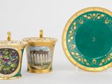 deux tasses et une soucoupe ornées d'une image représentant un palais