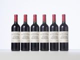six bottles of red wine lined up in a row