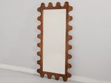 un miroir en bois posé sur un sol blanc, près d'un mur