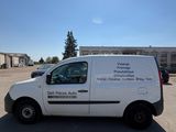 a white van parked in a parking lot in front of a building