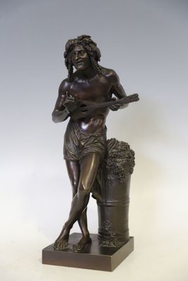 statue représentant une femme tenant un panier de raisins, posée sur un socle en bois