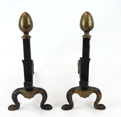 une paire de bougeoirs anciens en laiton posés sur des socles en fonte