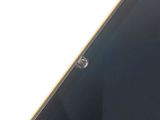 the back of a black cell phone with a hole in the middle of it
