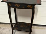 table d'appoint peinte en noir et or, avec une étagère
