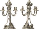 paire de chandeliers plaqués argent avec des bougies sur leurs socles