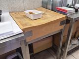 a kitchen with a sink and a counter with a cutting board on it