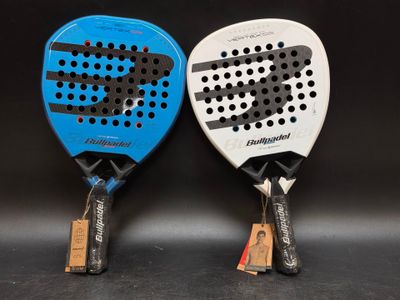 two tennis racquets sitting next to each other on a black surface