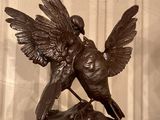 une statue représentant un oiseau perché sur un livre