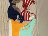 plusieurs maillots de bain étalés sur un lit dans une chambre