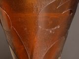 a brown glass vase sitting on top of a wooden table