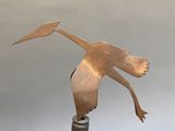 a metal sculpture of a bird that is on top of a bottle