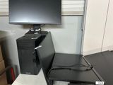 un ordinateur de bureau posé sur un bureau, à côté d'un écran