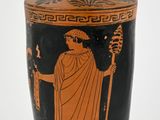 a black and orange vase with an image of a man holding a staff