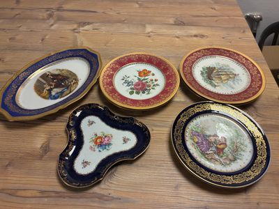 four plates with different designs on them sitting on a wooden table