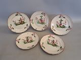 quatre assiettes ornées de fleurs et d'oiseaux, posées sur une table