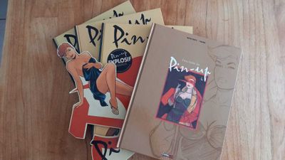 three books that are sitting on a wooden table