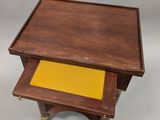 an old wooden table with a yellow tray on top