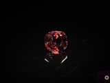 a close up of a red diamond on a black surface