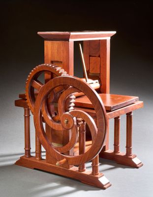 une photo représentant une maquette en bois d'une machine à filer posée sur une table