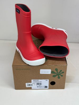 une paire de bottes de pluie rouges posée sur une boîte en carton