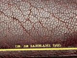 a brown leather wallet with a yellow line on it
