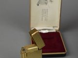 a small gold lighter sitting in a case on a table