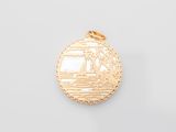 a close up of a gold pendant with a boat on it
