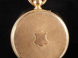 an antique gold pocket watch with a gold chain