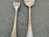 deux cuillères en argent et une fourchette posées sur une table